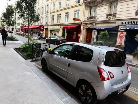 Silver hatchback Renault Twingo parked on a narrow Paris street by cafes, b.. Stock Photos