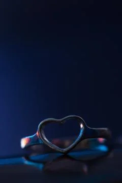 Silver heart shape ring with blue background Stock Photos