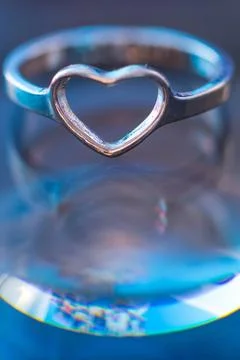 Silver heart shape ring with light blue background Stock Photos