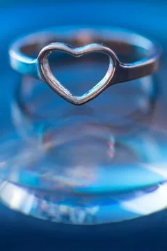 Silver heart shape ring with light blue background Stock Photos