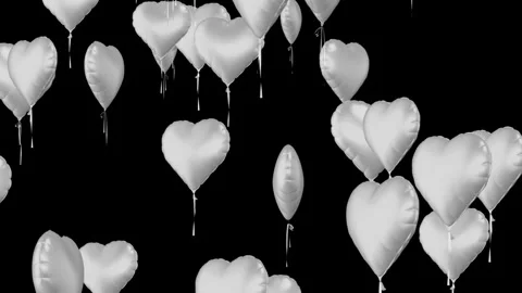 Silver heart shaped balloons float up against black background Stock Footage 327594920