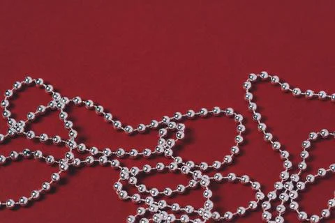 Silver holiday decorations on a red background. Stock Photos
