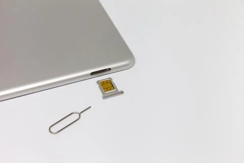 Silver inverted tablet. The SIM card tray is open. Stock Photos