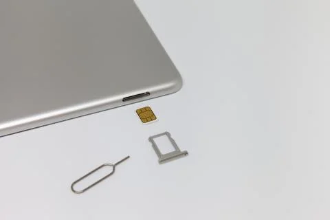 Silver inverted tablet. The SIM card tray is open. Stock Photos