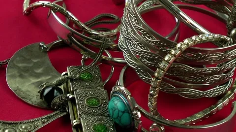 Silver jewellery rotating on red background Stock Footage 68035915