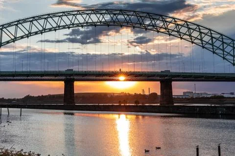 Silver Jubilee Bridge in Runcorn with the sun setting in the background Stock Photos