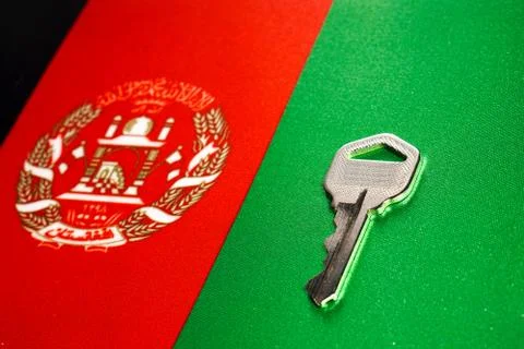 Silver key on the flag of Afghanistan. Close-up, copy space Stock Photos