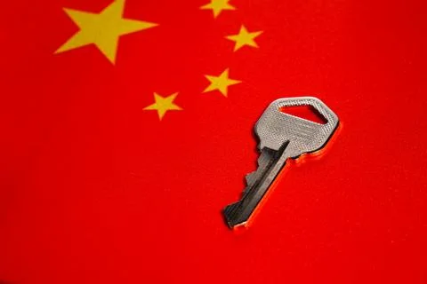 Silver key on the flag of China. Close-up, copy space Stock Photos