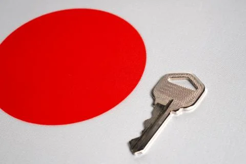 Silver key on the flag of Japan. Close-up, copy space Stock Photos