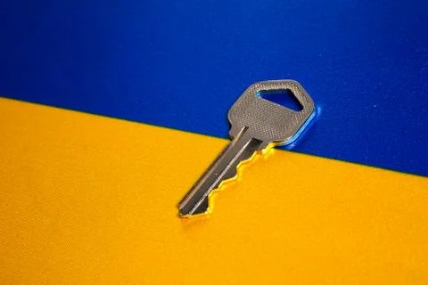 Silver key on the flag of Ukraine. Close-up, copy space Stock Photos
