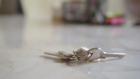 Silver keys lying on white marble surface in bright interior environment wi.. Stock Footage 332626299