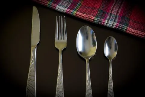 Silver knife, fork, spoon, teaspoon on the dark reflective backdrop. Foto stock
