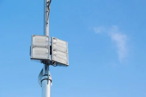 Silver lamp post with a light LED bulb on the left side and background sky. Stock Photos