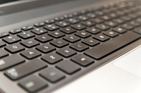 Silver laptop computer keyboard with black keys close up 写真素材