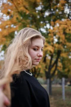 A silver large chain hangs around the girl's neck Stock Photos