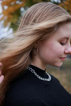 A silver large chain hangs around the girl's neck Stock Photos