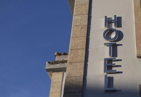 Silver lettering attached to a wall identifying a building as a hotel Foto stock