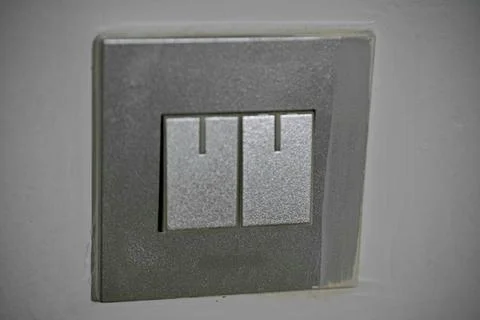 A silver light switch with two switches on it Stock Photos