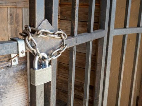 Silver lock and thick chain barring entrance to wooden door Stock Photos