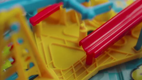 Silver marble rolling down a red slide into a plastic bucket Vídeos de archivo 328125749