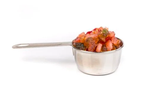 Silver measuring cup containing fruit cake mix side view Stock Photos