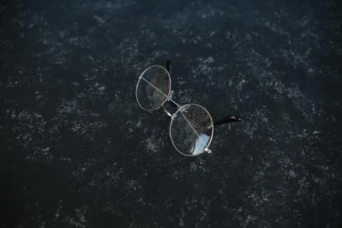 Silver metal glasses. On a solid black stone background. With a soft blurred  写真素材