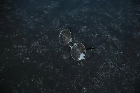 Silver metal glasses. On a solid black stone background. With a soft blurred  写真素材