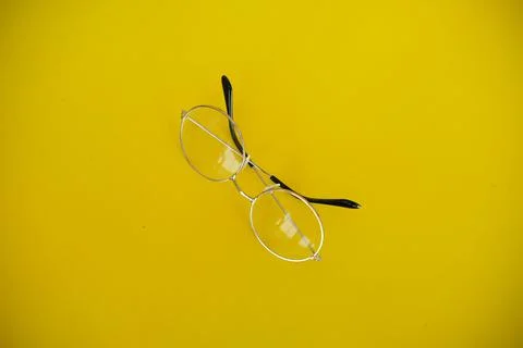 Silver metal glasses. On a solid yellow background. With a soft blurred elect Foto stock