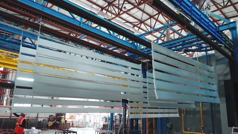 Silver metal panels move on an overhead conveyor. Powder coating line Stockbeeldmateriaal 146100707