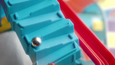 Silver metallic marble rolling down a blue and red slide (board game) Vídeos de archivo 328126251