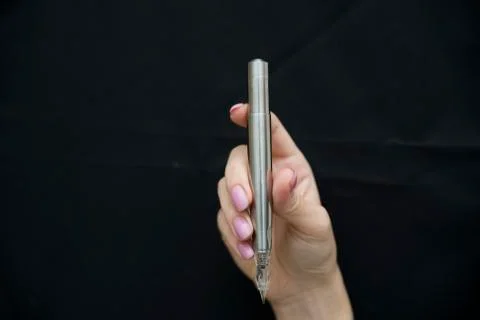 Silver microblading pen for eyebrow on black background Stock Photos