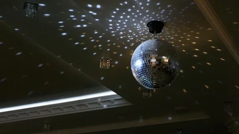 Silver mirror disco ball rotating in restaurant Stock Footage 90358601