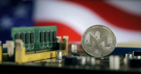 Silver Monero XMR coin on the computer motherboard  in front of the USA flag. Video stock 92926618