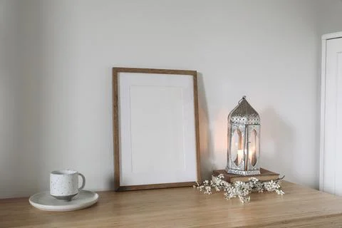 Silver Moroccan lantern, cup of tea, coffee on table. Wooden picture frame Stockfoto's
