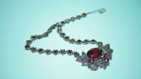 Silver necklace with ruby on a blue background. fashion design Video stock 124570888