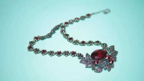 Silver necklace with ruby on a blue background. fashion design 스톡 사진