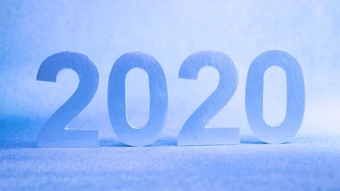 Silver numbers of 2020 on a blue background in the light of a garland, close- Stock Footage 110727880