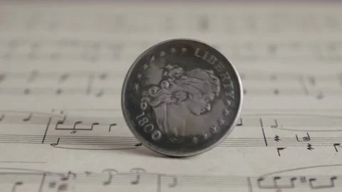 Silver Old Coin Rotating On The Sheet Of Music Close Up. Spinning American Stock Footage 150564307