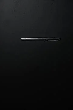 Silver pen on a black background. Vertical business concept with copy space.. Stock Photos