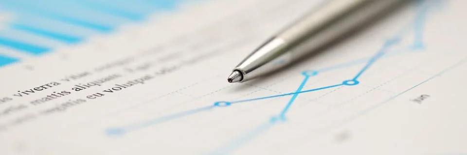 Silver pen lying down at important statistic document at empty working table Stock Photos