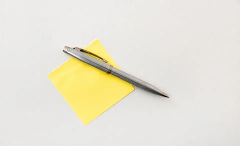 Silver Pen on Yellow Sticky Note Stock Photos