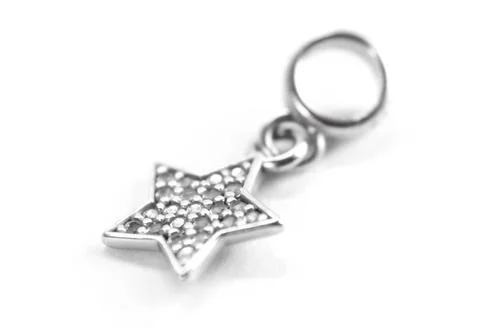 Silver pendant in the form of asterisks. Close up. Isolated on a white backgr Stock-Fotos