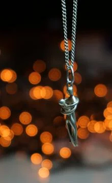 Silver pendant on a silver chain with bokeh background Stock Photos