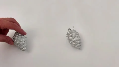 Silver Pine Cones on White Surface with Glittery Holiday Shine Stock-Footage 323694416