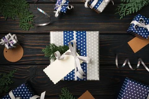 Silver present box with empty gift tag on blue wooden background. Birthday,.. Stock Photos