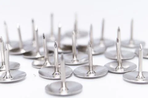 Silver Push Pins on White Background, Office Supplies, Close-Up View. Stock Photos