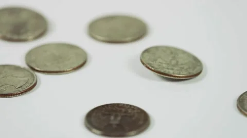 Silver quarters falling and bouncing on a white background Stock Footage 329595917