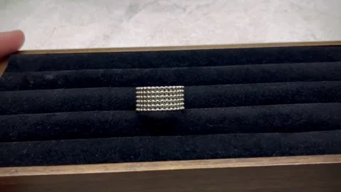 Silver ring featuring a unique bead design is presented on black velvet display Stock Footage 336311642