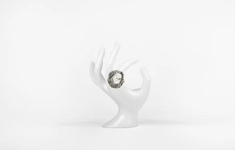 Silver ring with pearl on plastic hand on white background. 库存照片