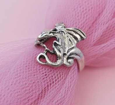 Silver ring on a pink background. Close-up. Selective focus. Stock Photos